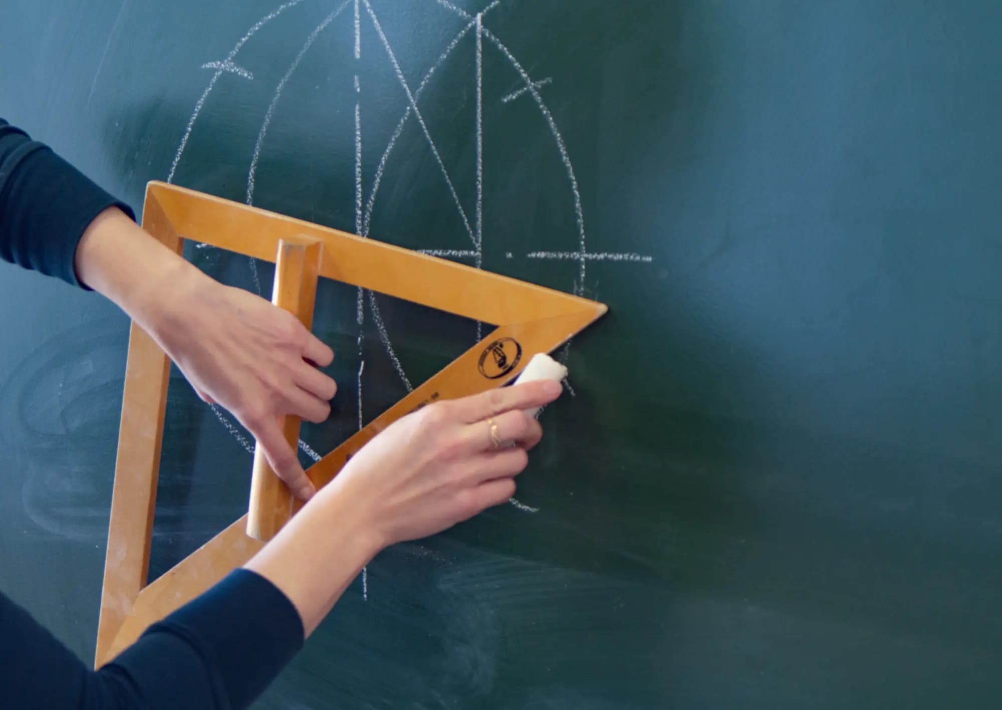 Rysowanie figury geometrycznej na tablicy przy użyciu ekierki.